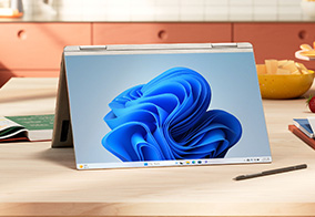 Laptop folded outward to create a display. Laptop screen shows Windows 11 desktop background.