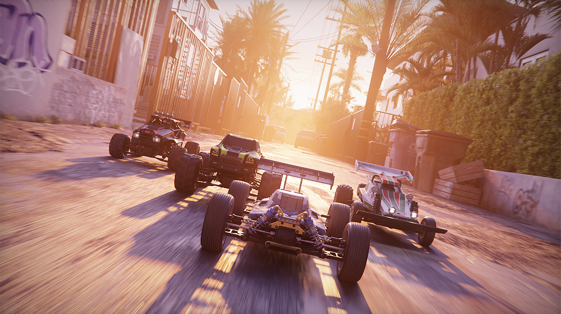 Four RC cars in a V formation racing through tropical urban backstreets.